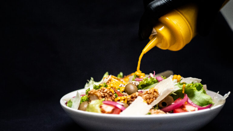 De la sauce secrète en train d'être versée sur une salade